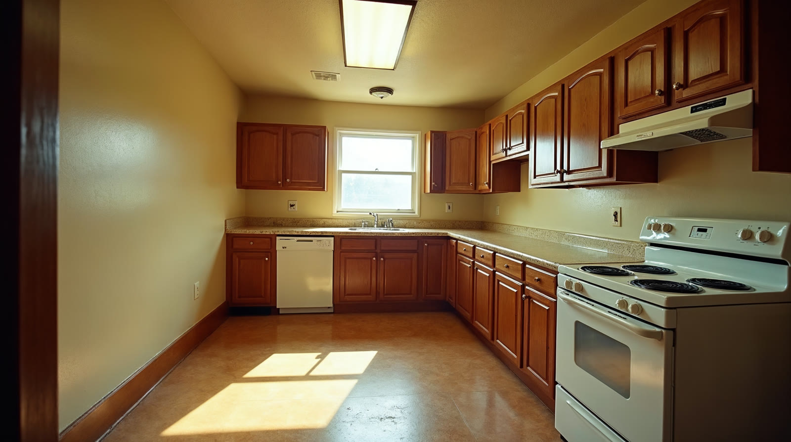 Dated kitchen in a Bedford, Texas home before remodeling by Limarti Group: dark oak cabinets and worn laminate countertops